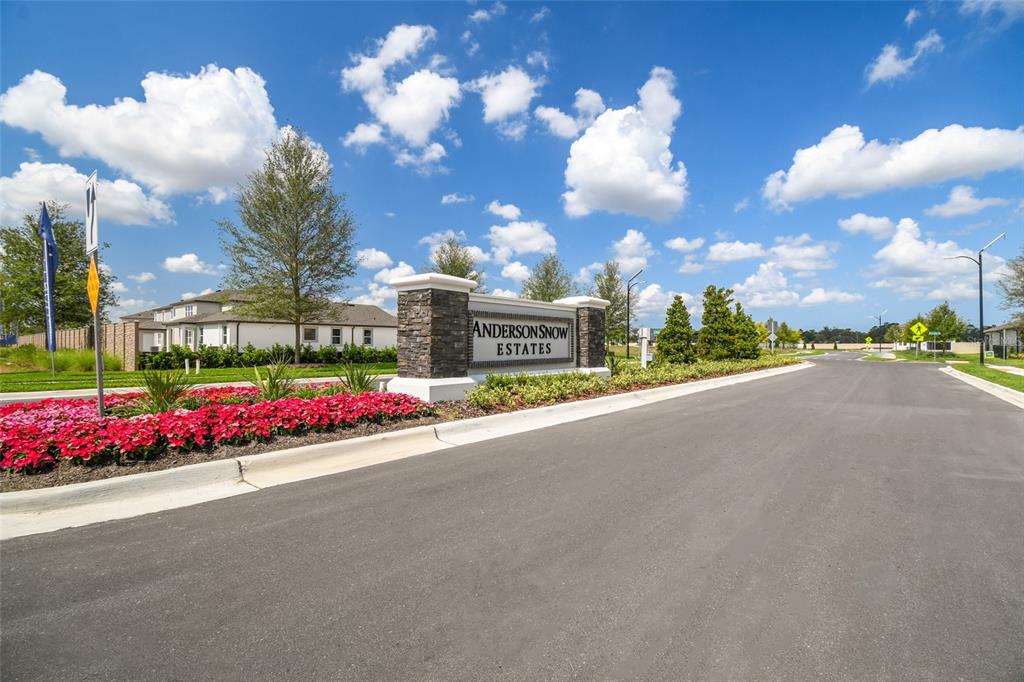 A stone monument sign for Anderson Snow Estates stands beside a road with landscaping — 2237 CLARY SAGE DRIVE, SPRING HILL, FL