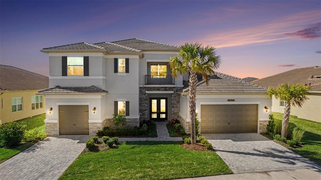 A two-story house with a stone facade, two garages, and a palm tree in front — 3263 JUNIPER SPRINGS STREET, WESLEY CHAPEL, FL