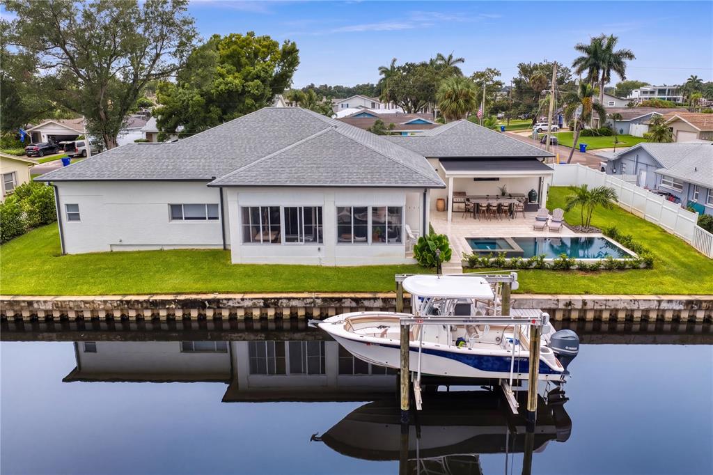 An aerial view shows a white house with a pool and a boat on a lift — 4091 13TH WAY NE, ST PETERSBURG, FL