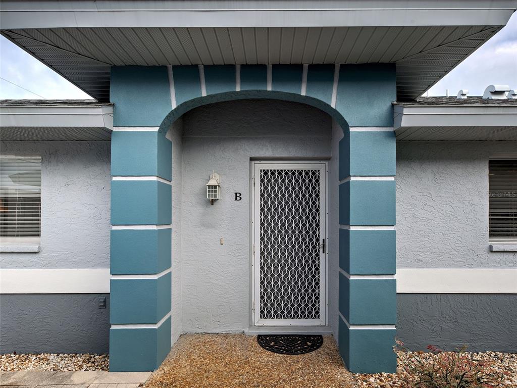 The exterior entrance features a blue arched entryway with a white security door — 6527 HAMLET DRIVE UNIT 26B, ENGLEWOOD, FL