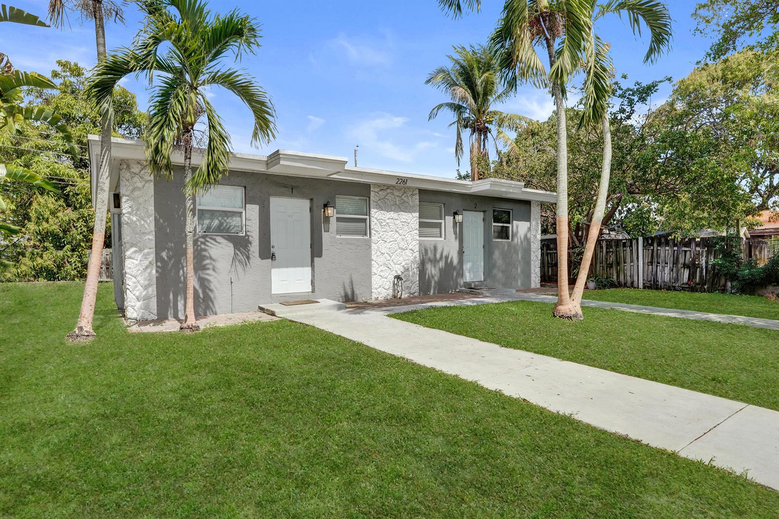 A single-story duplex with gray stucco walls, white stone accents, and two front doors — 2261 NW 2nd Street, Pompano Beach FL 33069, POMPANO BEACH, FL