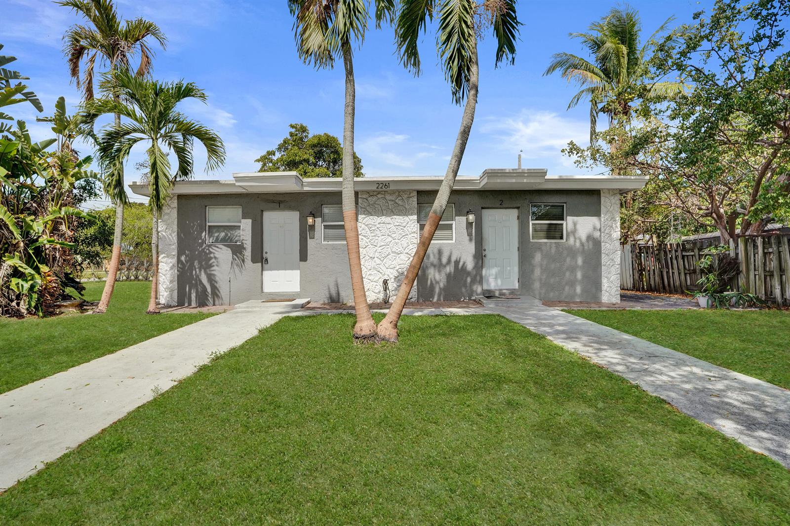 A single-story duplex with gray stucco walls, white stone accents, and two front doors — 2261 NW 2nd Street, Pompano Beach FL 33069, POMPANO BEACH, FL