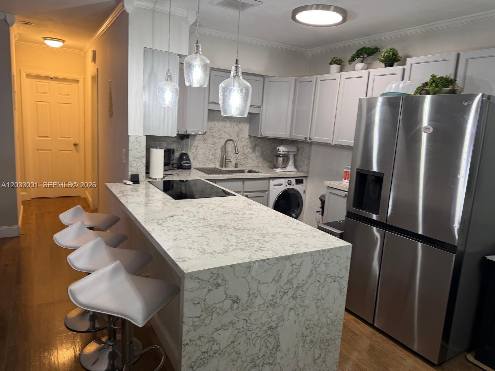 A kitchen features a marble-patterned island, stainless steel appliances, and light gray cabinetry — 500 Layne Blvd # 12, Hallandale Beach FL 33009, HALLANDALE BEACH, FL