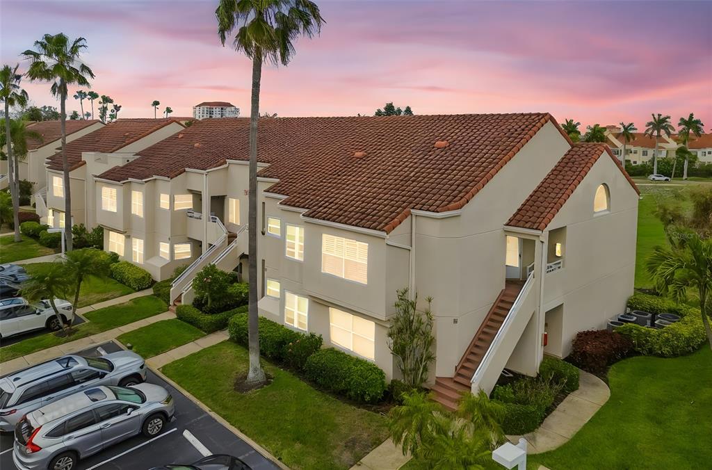 An exterior view of a multi-story apartment building with a tile roof and palm trees — 6000 BAHIA DEL MAR CIRCLE UNIT 134, ST PETERSBURG, FL