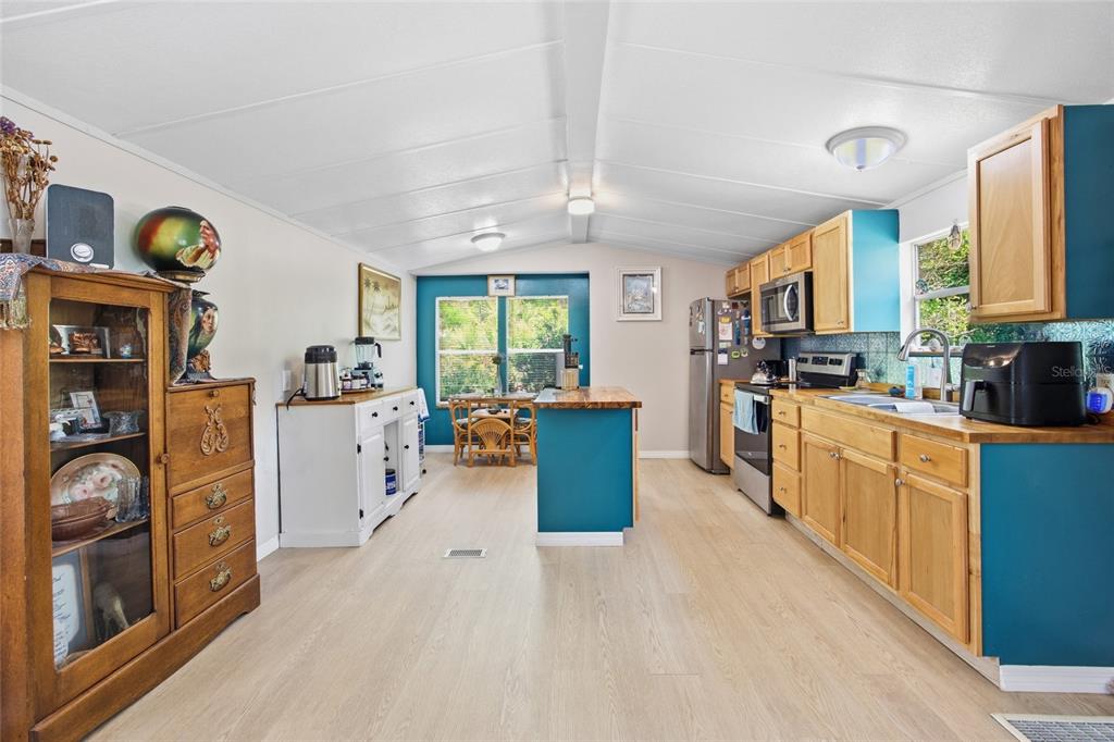 A small dining area features a rattan table and chairs against a blue accent wall — 2412 NW 116TH PLACE, GAINESVILLE, FL