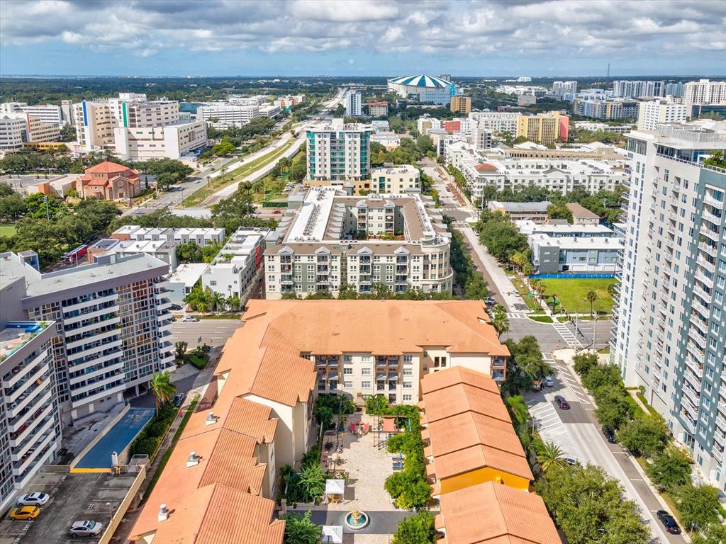 An aerial view shows a multi-story apartment complex with orange tile roofs and courtyards — 200 4TH AVENUE S UNIT 225, ST PETERSBURG, FL