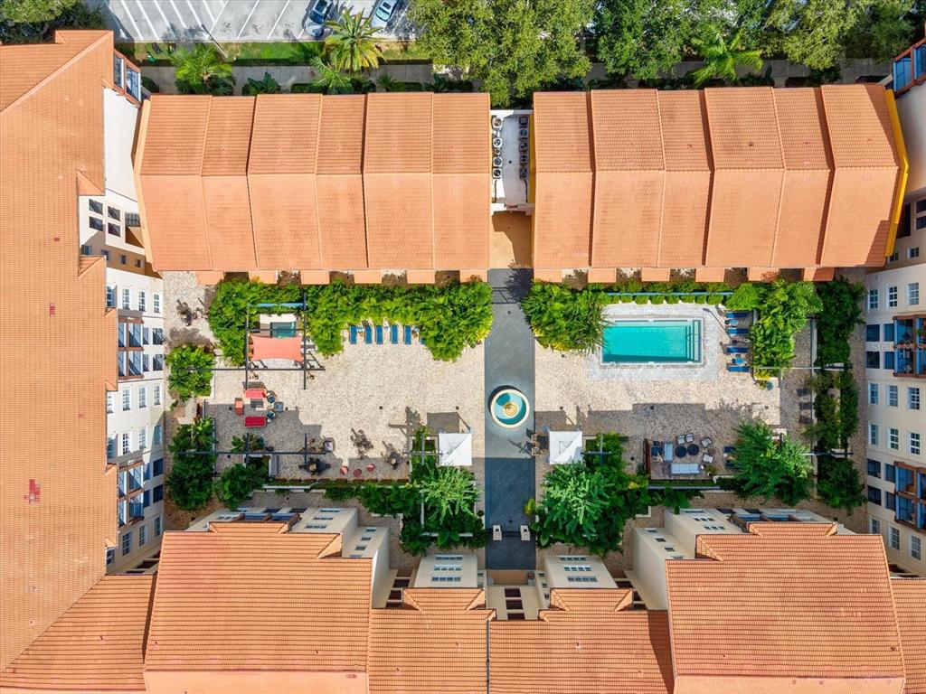 An aerial view shows a courtyard with a swimming pool surrounded by multi-story apartment buildings — 200 4TH AVENUE S UNIT 225, ST PETERSBURG, FL