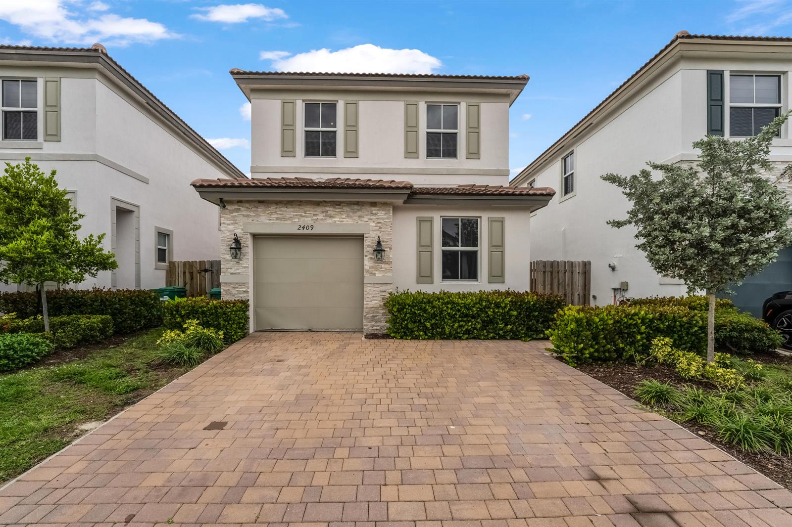 A two-story house with a stone-accented garage and a paved driveway — 2409 NW 131st Circle, Miami FL 33167, MIAMI, FL