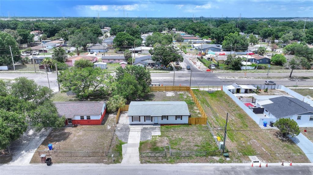An aerial view shows a single-story house with a fenced yard and a concrete driveway — 8204 ALLAMANDA AVENUE, TAMPA, FL