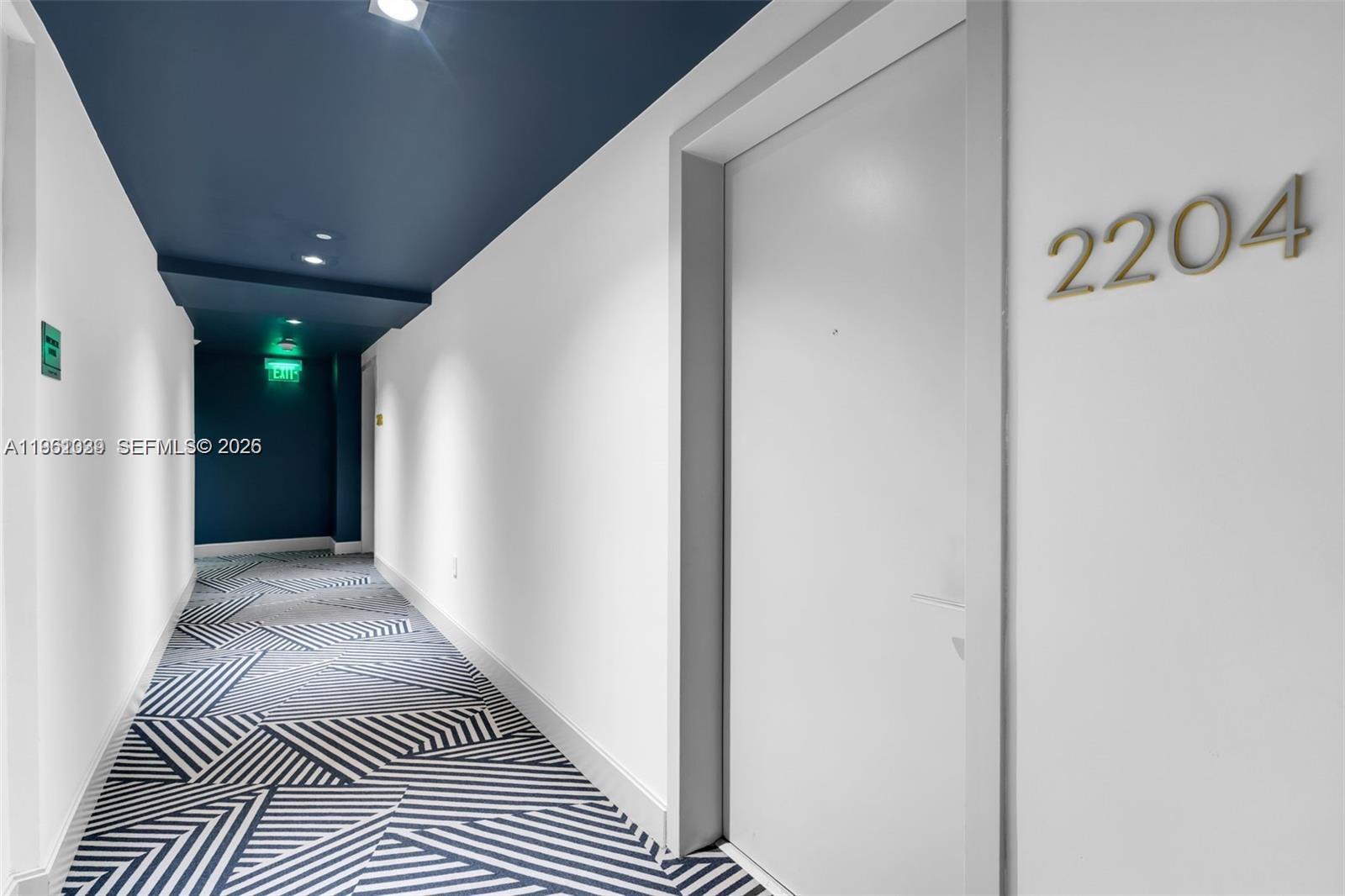A hallway features white walls, a dark blue ceiling, and a geometric patterned carpet — 45 SW 9th St # 2204, Miami FL 33130, MIAMI, FL