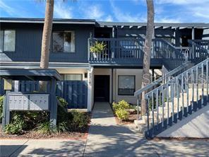 A two-story apartment building exterior features a blue facade, a balcony, and an outdoor staircase — 7214 CLOISTER DRIVE UNIT 7214, SARASOTA, FL