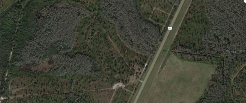 This aerial map view shows a wooded lot adjacent to a highway — S KENANSVILLE ROAD, OKEECHOBEE, FL