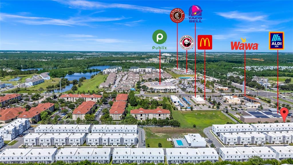 This aerial view shows a residential neighborhood with nearby commercial shopping centers and restaurants — 637 TRIKOMO DRIVE DRIVE, DAVENPORT, FL