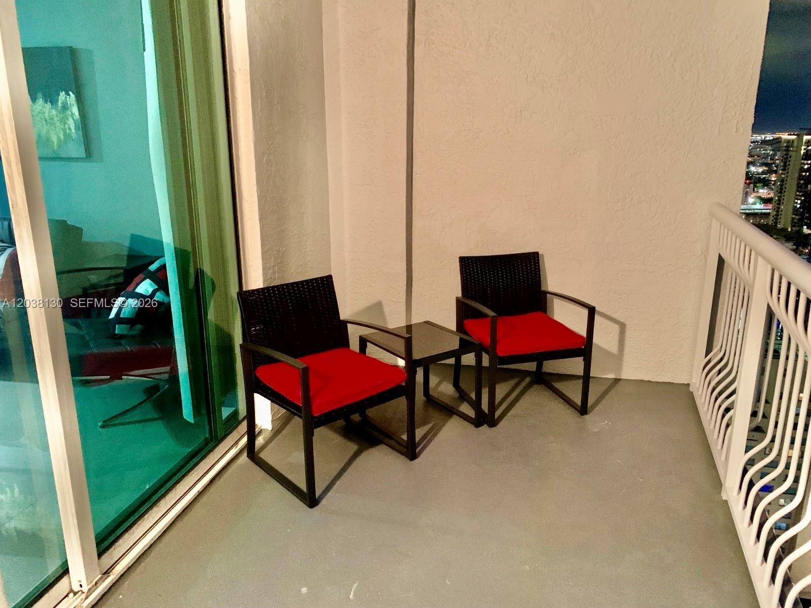 A balcony features two black chairs with red cushions and a small glass-topped table — 1200 Brickell Bay Dr # 4306, Miami FL 33131, MIAMI, FL