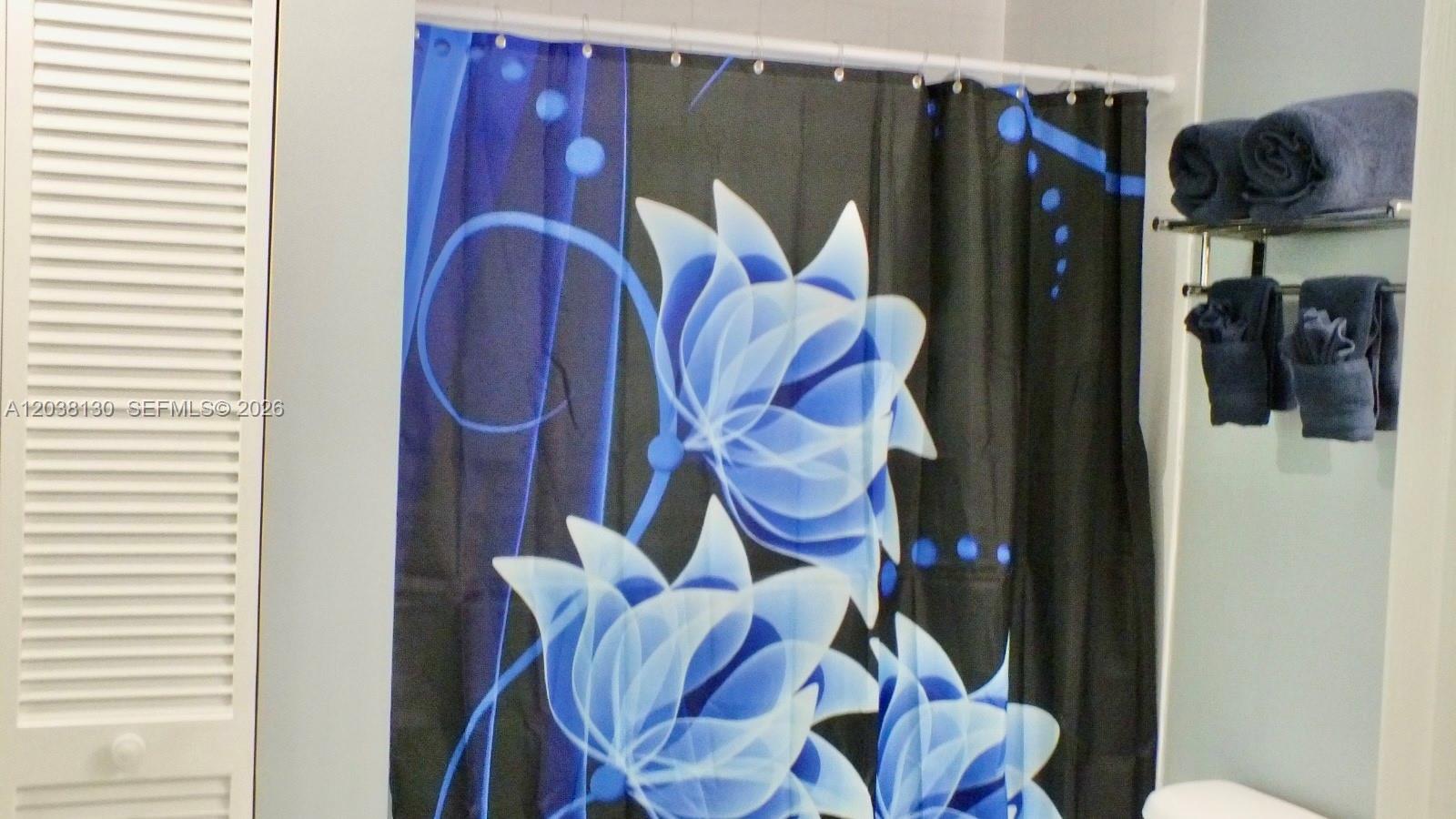A bathroom features a blue and black floral shower curtain and a towel rack — 1200 Brickell Bay Dr # 4306, Miami FL 33131, MIAMI, FL