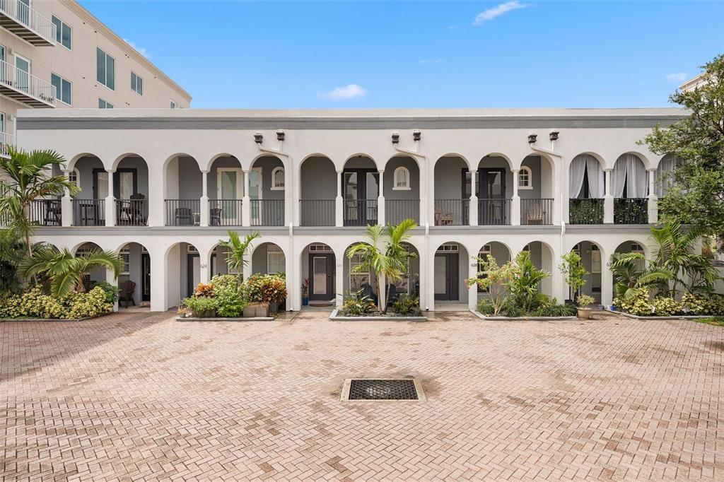 A two-story building with arched walkways and balconies overlooks a brick-paved courtyard — 628 3RD AVENUE S, ST PETERSBURG, FL