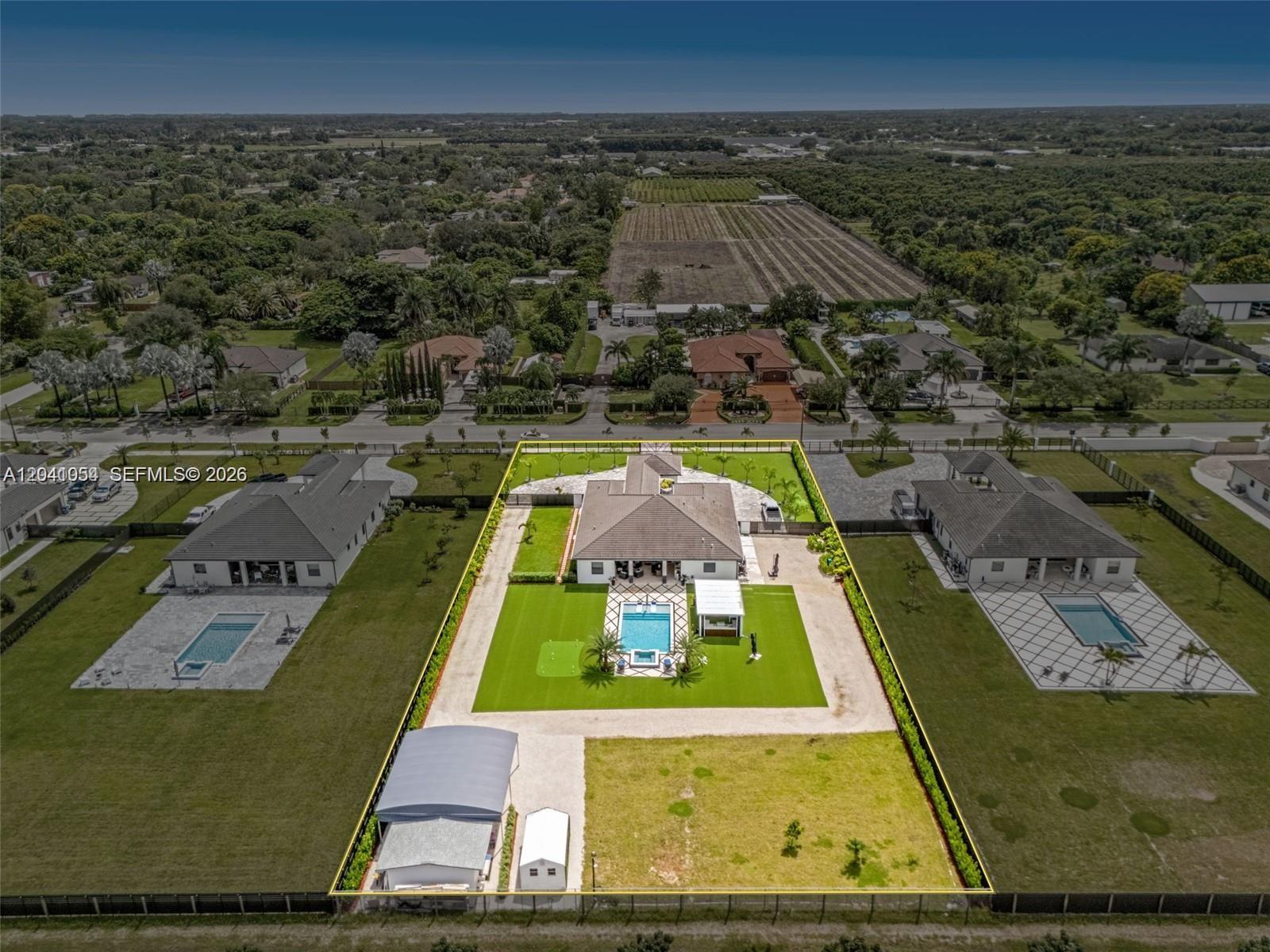 An aerial view shows a house with a pool, putting green, and detached garage — 18261 SW 224th St, Miami FL 33170, MIAMI, FL