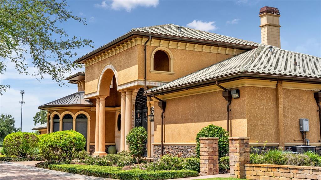 A tan stucco house with a tiled roof, stone base, and arched entryway — 5503 DOWNING STREET, DOVER, FL