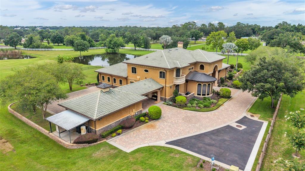 An aerial view shows a large, two-story stucco house with a tile roof and driveway — 5503 DOWNING STREET, DOVER, FL
