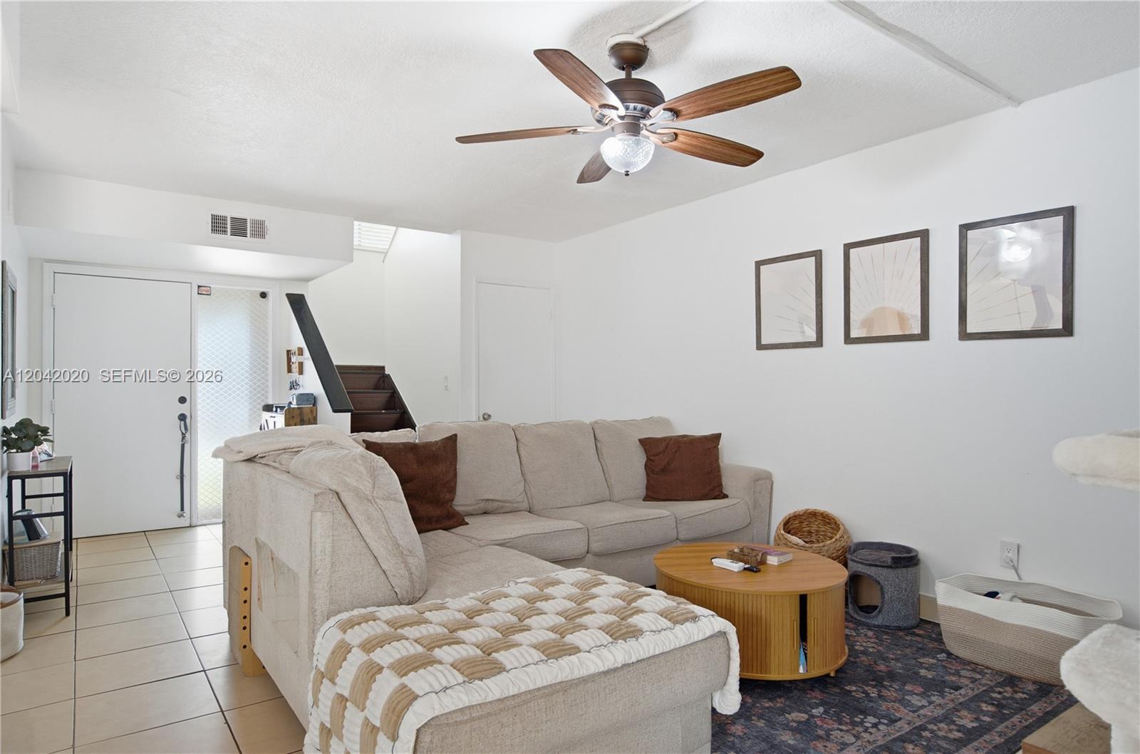 A living room features a beige sectional sofa, a wooden coffee table, and a ceiling fan — 10327 NW 9th St Cir # 7, Miami FL 33172, MIAMI, FL