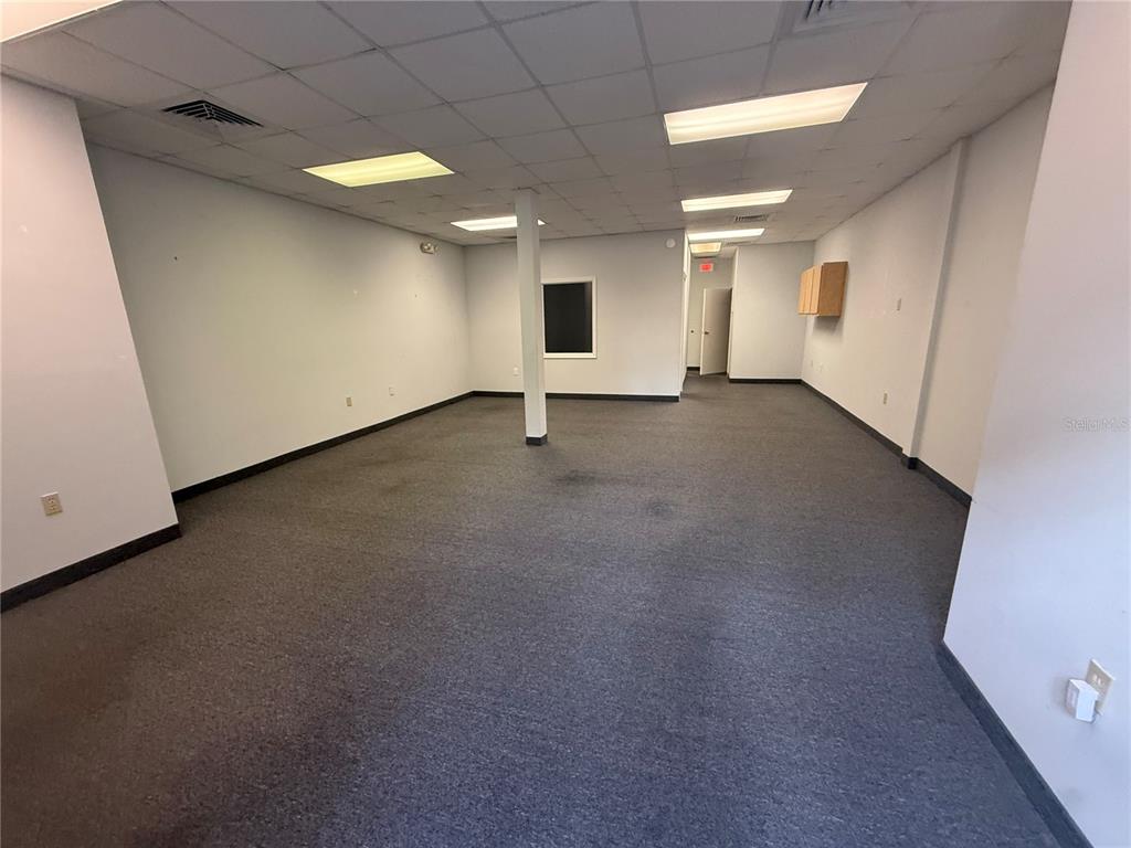 An empty office space features gray carpeting, white walls, and a drop ceiling with lights — 2011 SW 20TH PLACE UNIT 103, OCALA, FL