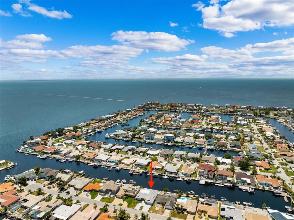 A paved patio overlooks a canal with outdoor furniture and a potted plant — 5041 CABRILLA COURT, NEW PORT RICHEY, FL