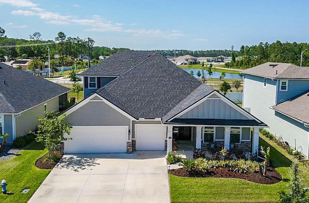 An aerial view of a single-story suburban house with a gray roof and driveway — 158 WOOD STORK LANE, PALM COAST, FL