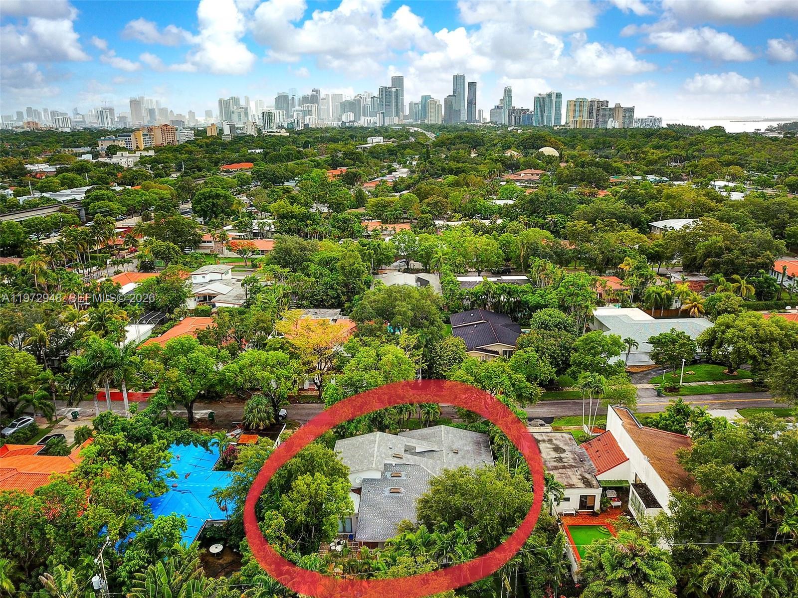 An aerial view shows a single-story house surrounded by lush trees in a residential neighborhood — 84 Bay Heights Dr, Miami FL 33133, MIAMI, FL