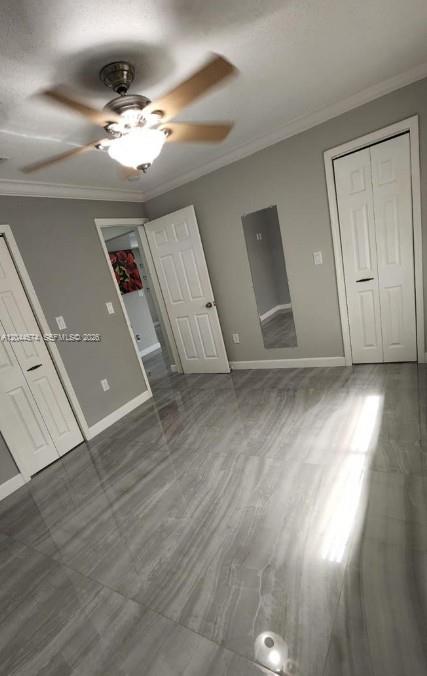 A bedroom with gray walls, a ceiling fan, and glossy gray tile flooring — LAKE WORTH, FL