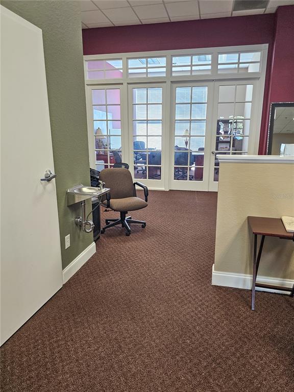 An office space features brown carpet, a wall-mounted water fountain, and glass-paned double doors — 422 S ALAFAYA TRAIL UNIT 30, ORLANDO, FL