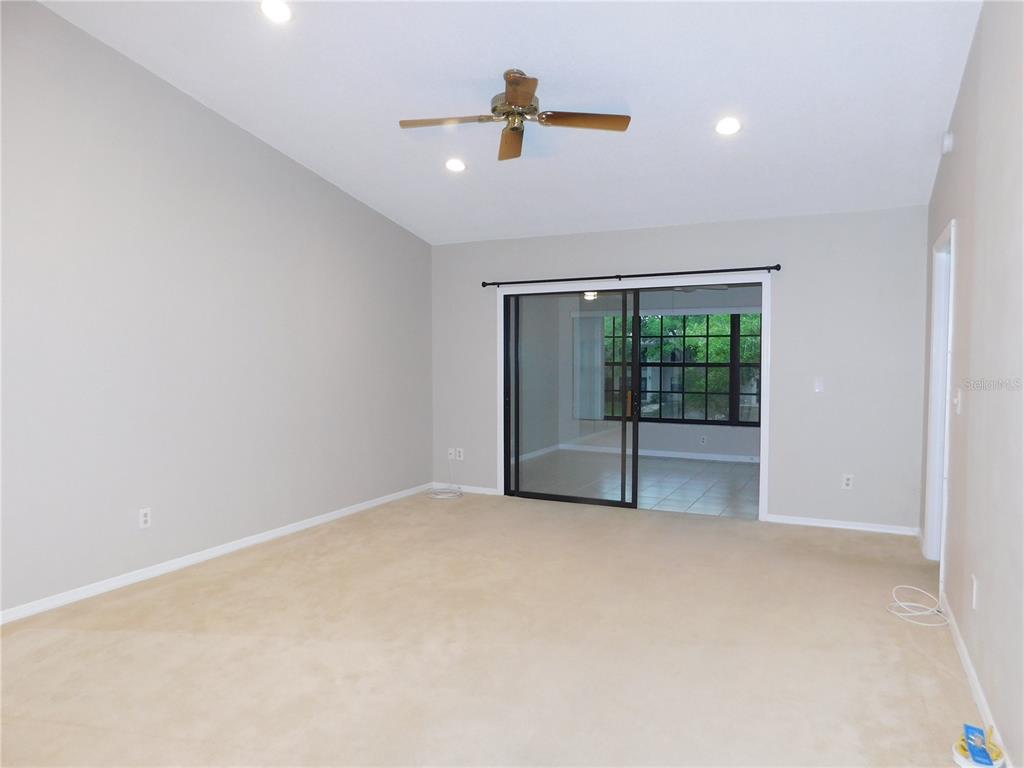 A carpeted room with a ceiling fan, recessed lighting, and sliding glass doors to a patio — 2150 ELM STREET UNIT 606, DUNEDIN, FL