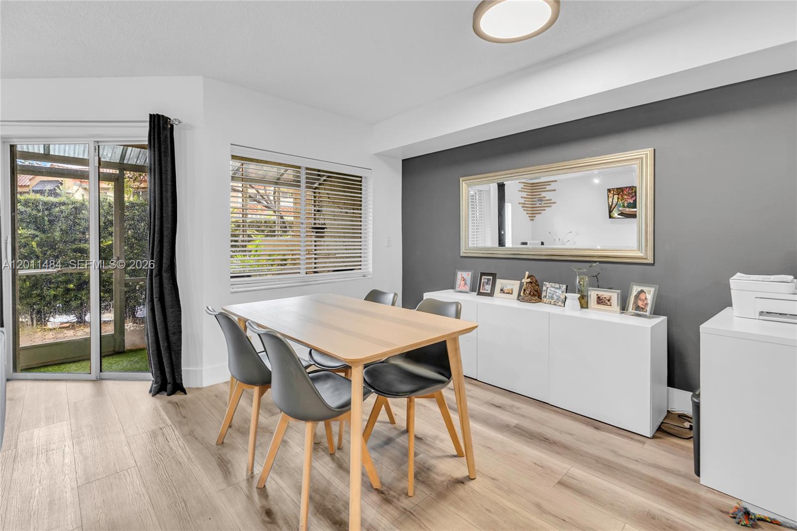 A dining room features a gray accent wall, a white sideboard, and a wooden table — 7874 NW 7th Ct, Plantation FL 33324, PLANTATION, FL