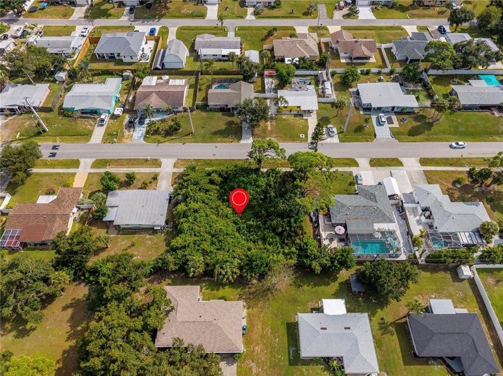 An aerial view shows a vacant, tree-covered residential lot surrounded by houses in a neighborhood — 31 W SEMINOLE DRIVE, VENICE, FL