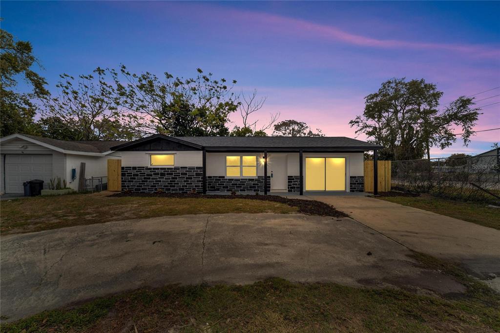 A single-story house with a white and black stone exterior, a driveway, and a garage — 4012 VALENCIA DRIVE, NEW PORT RICHEY, FL