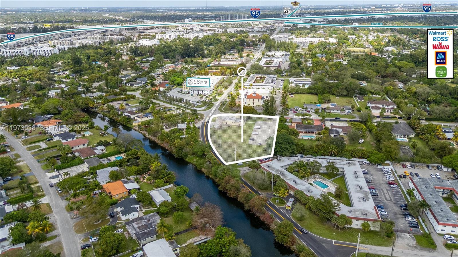 An aerial view shows a vacant lot outlined in white next to a canal — 15343 NW 2nd Ave, Miami FL 33169, MIAMI, FL