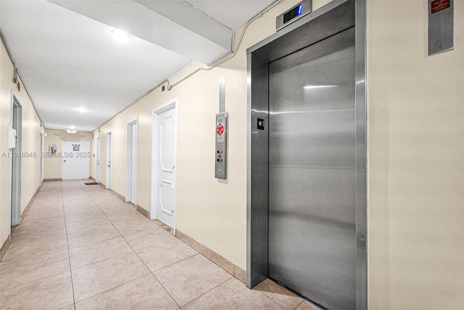 A hallway features tile flooring, several white doors, and a stainless steel elevator — 1830 Dixieanna St # 506, Hollywood FL 33020, HOLLYWOOD, FL