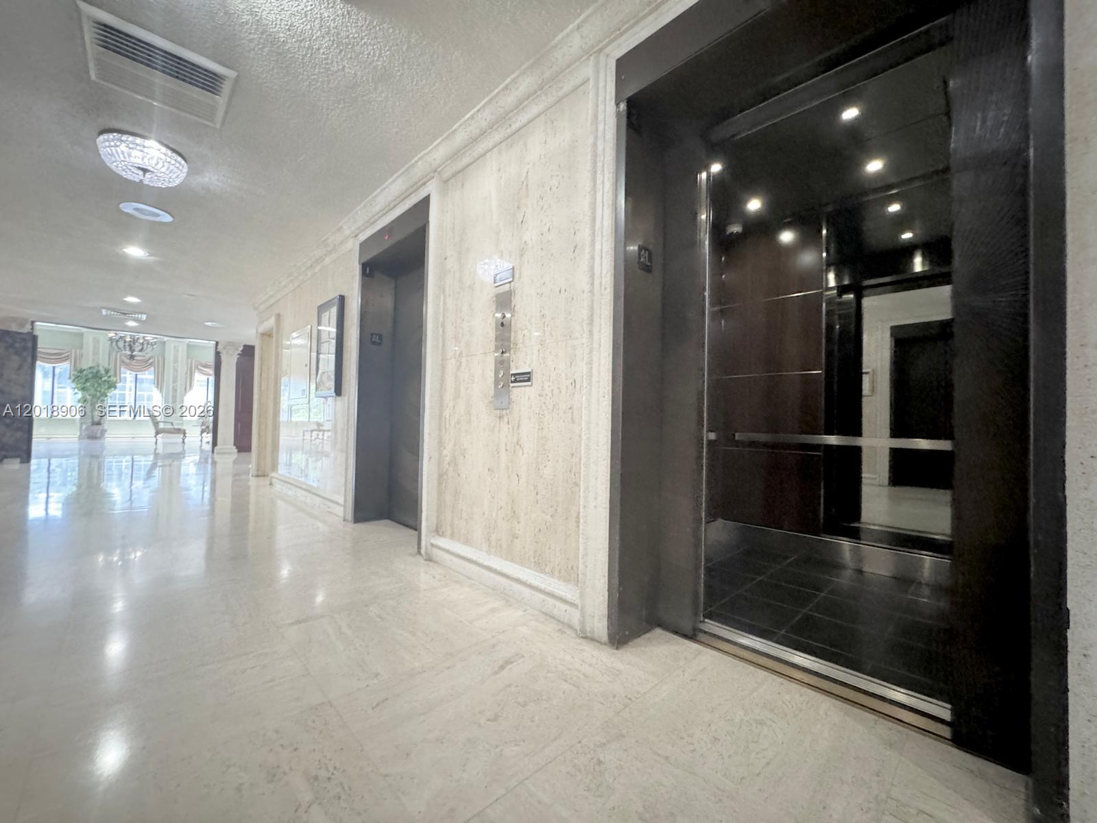 This kitchen features dark wood cabinets, stainless steel appliances, and a light-colored countertop — 600 Three Islands Blvd, Hallandale Beach FL 33009, HALLANDALE BEACH, FL