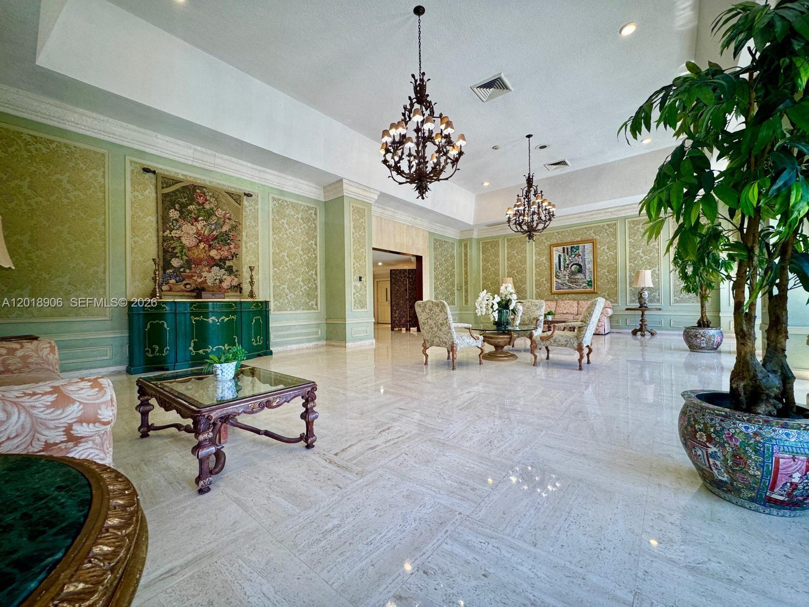 An open-concept living and dining area features hardwood floors, a glass table, and a balcony — 600 Three Islands Blvd, Hallandale Beach FL 33009, HALLANDALE BEACH, FL