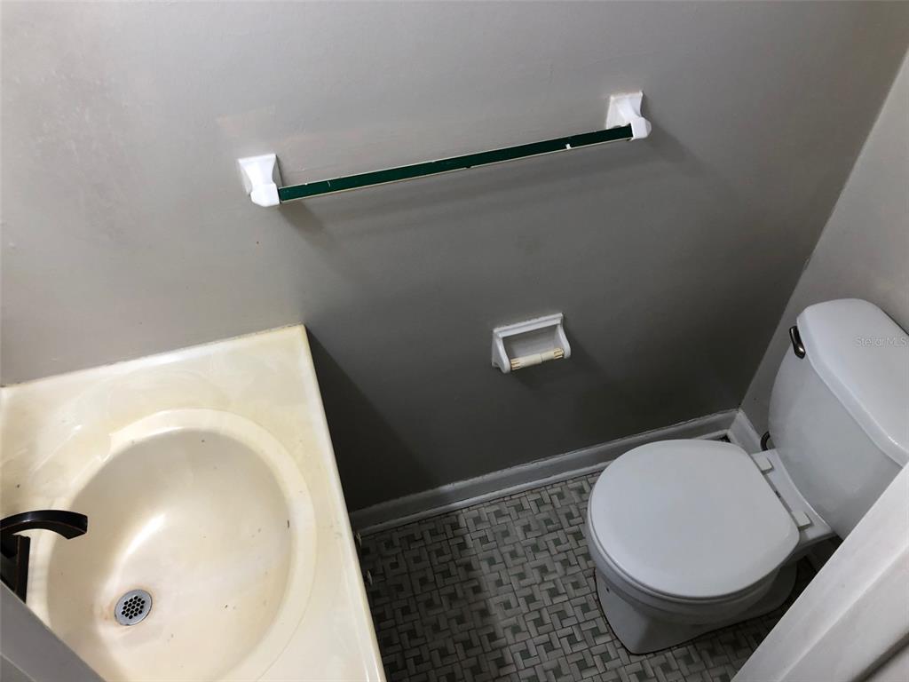 A small bathroom features a white sink, a toilet, and a wall-mounted towel bar — 304 NW 36TH STREET, GAINESVILLE, FL