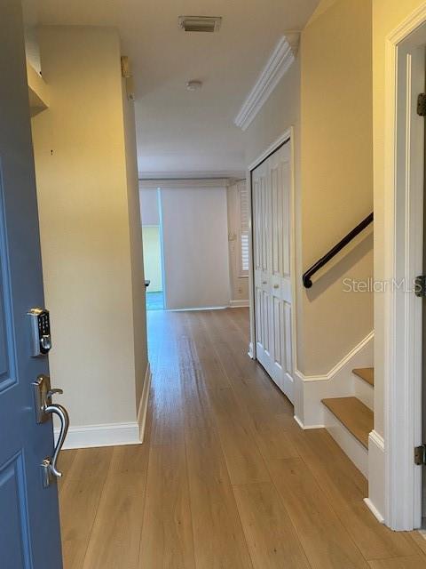 An entryway with light wood flooring leads to a hallway with stairs and a closet — 10034 TATE LANE, TAMPA, FL