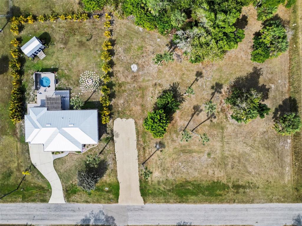 An aerial view shows a house with a metal roof, pool, and long gravel driveway — 410 E HENRY STREET, PUNTA GORDA, FL