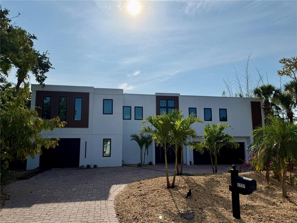 A two-story modern house with a white facade, dark accents, and a paved driveway — 1257 TREE BAY LANE, SARASOTA, FL
