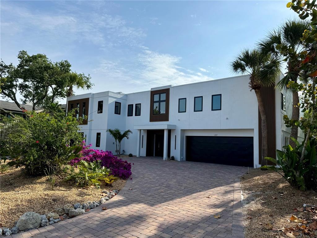 A modern two-story house with a white exterior, dark accents, and a paved driveway — 1257 TREE BAY LANE, SARASOTA, FL