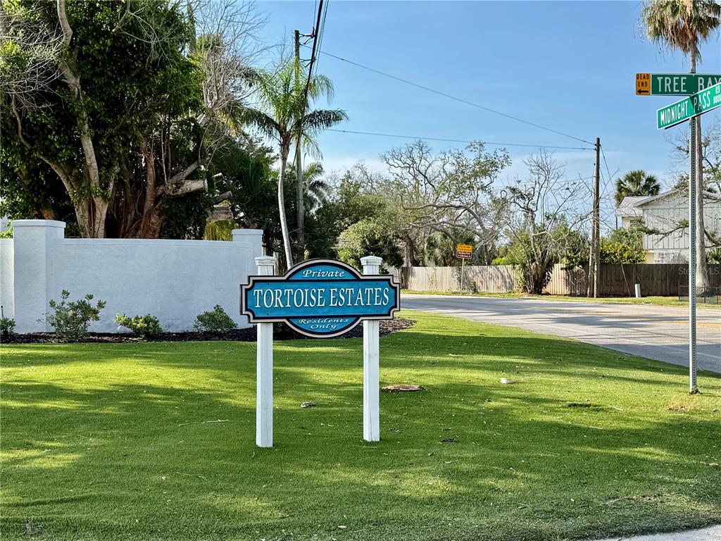 A sign for Tortoise Estates stands on a grassy lawn near a street intersection — 1257 TREE BAY LANE, SARASOTA, FL