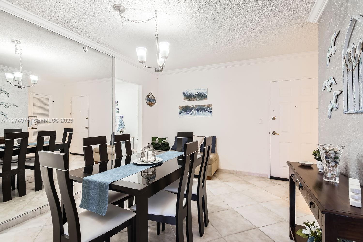 A dining room features a dark wood table, white chairs, a mirrored wall, and tile flooring — 2501 S Ocean Dr, Hollywood FL 33019, HOLLYWOOD, FL