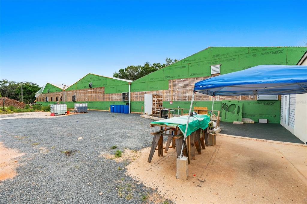 An exterior view of a large building under construction with green sheathing and a canopy — 3510 WALK IN WATER ROAD, LAKE WALES, FL