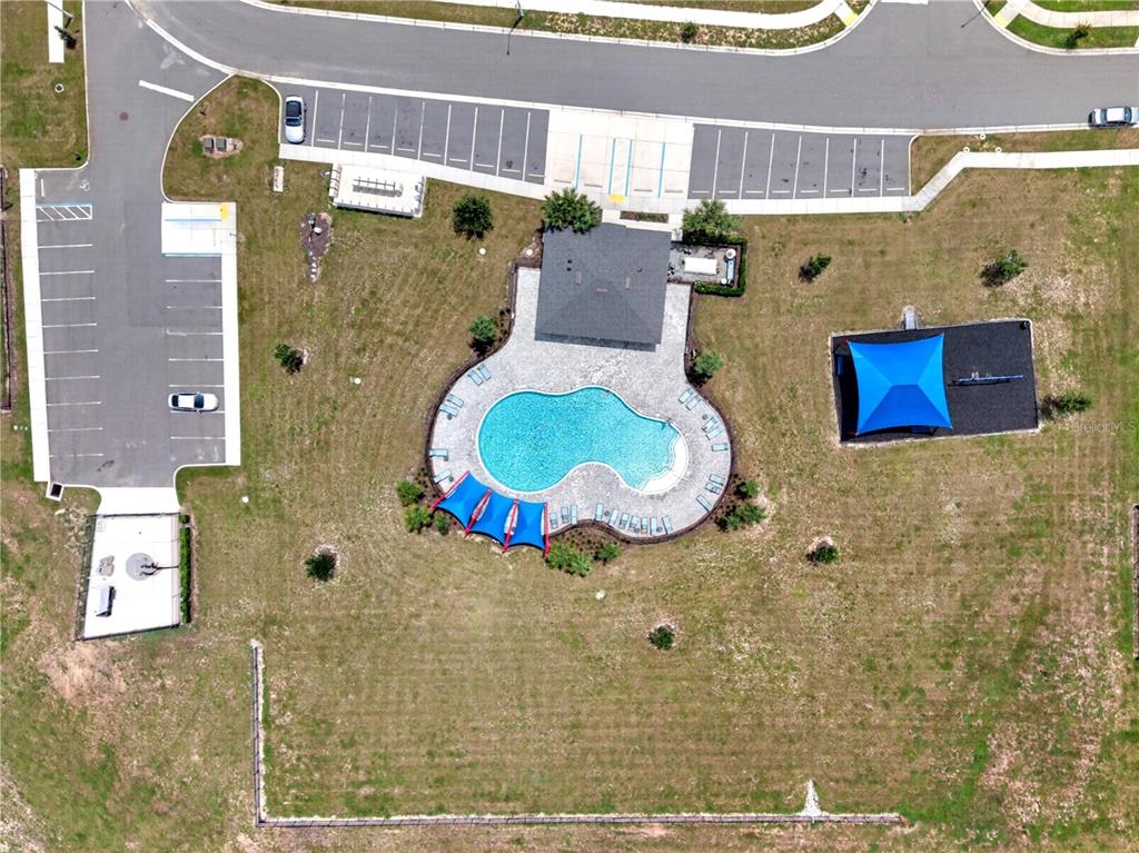 An aerial view shows a swimming pool, a covered pavilion, and a playground with parking — 598 TANARO LANE, HAINES CITY, FL