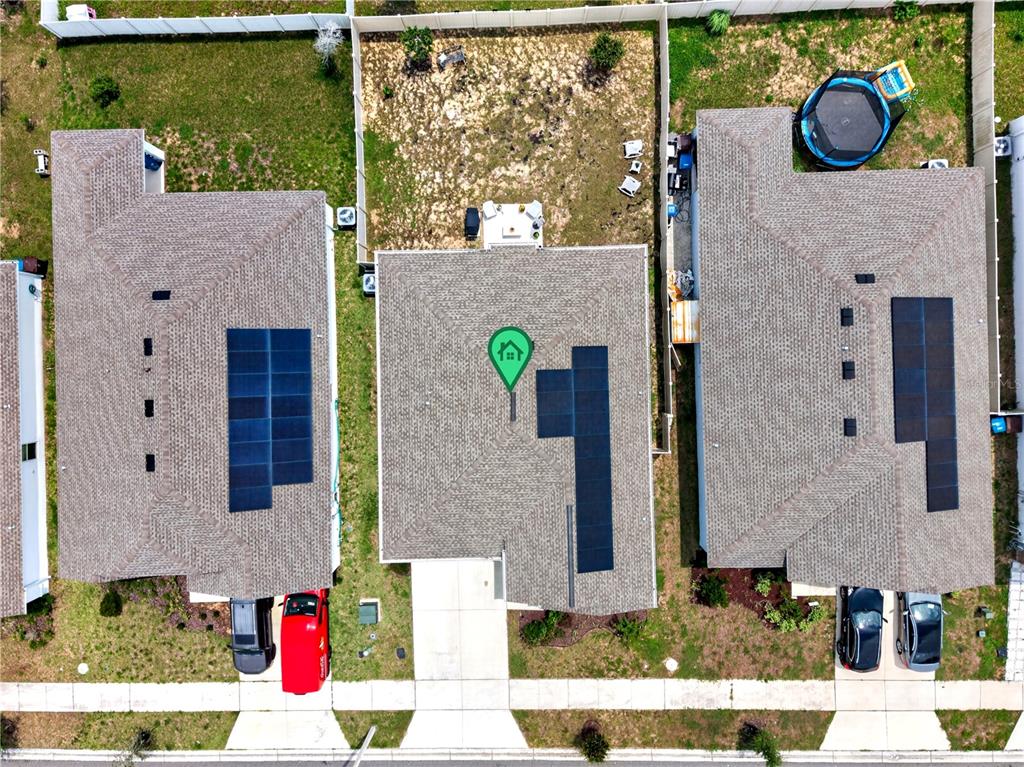 Aerial view of three suburban houses with solar panels on their roofs and driveways — 598 TANARO LANE, HAINES CITY, FL