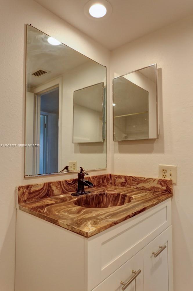 A bathroom vanity features a brown marble countertop, a white cabinet, and two mirrors — 8020 SW 17th Pl # 5, Davie FL 33324, DAVIE, FL