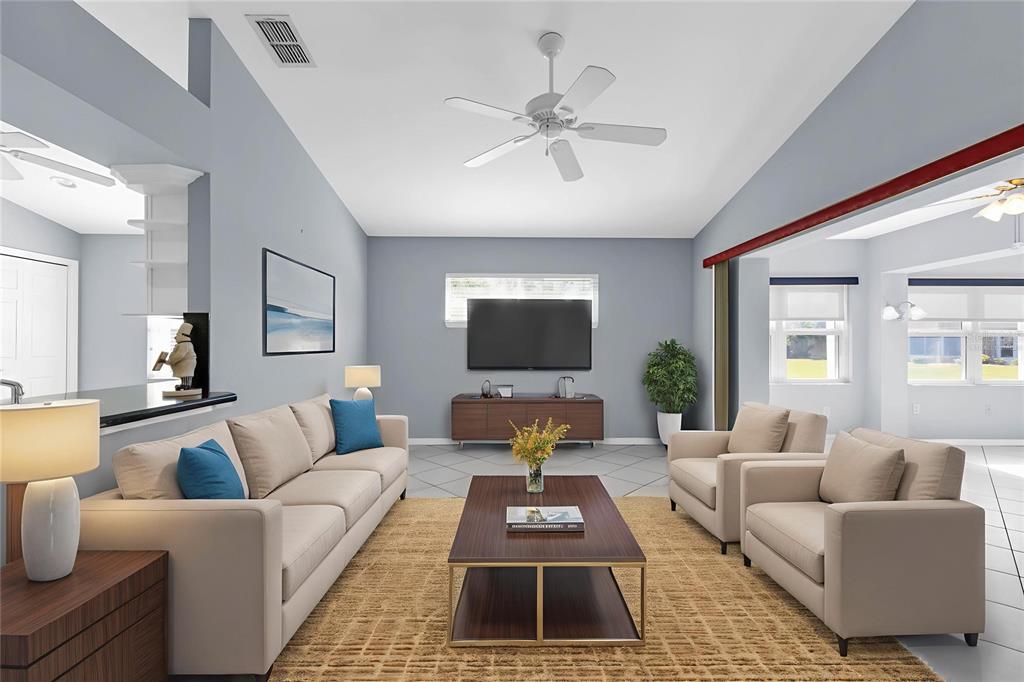 A living room features a beige sofa, two armchairs, a coffee table, and a wall-mounted television — 1713 PALACE COURT, PUNTA GORDA, FL